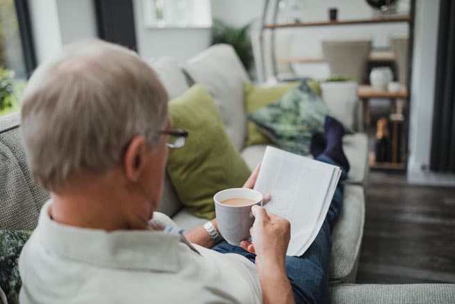 man drinking coffee while reading