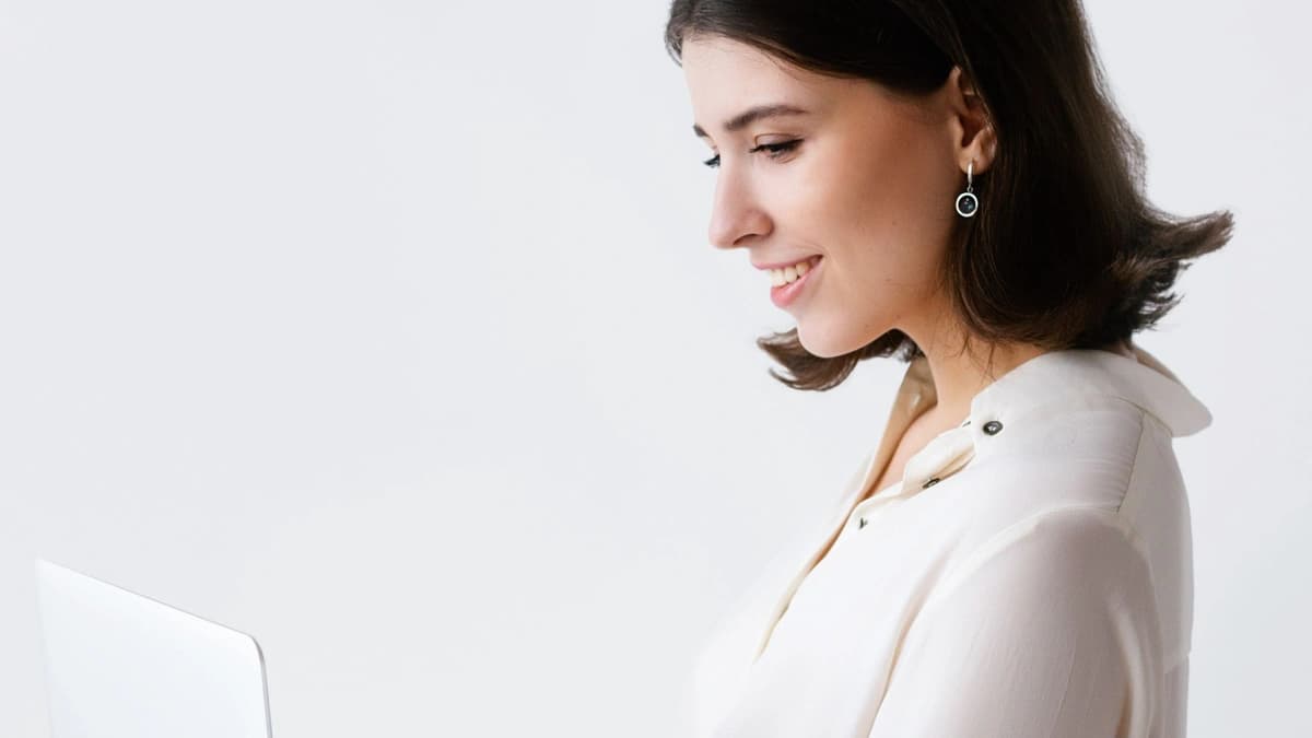 side profile of woman smiling and working on computer