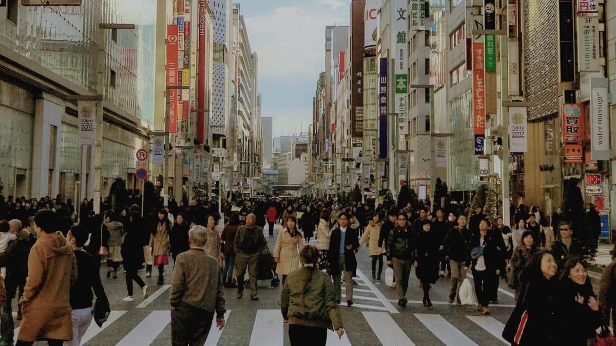 crowded of people in a crosswalk on a city street