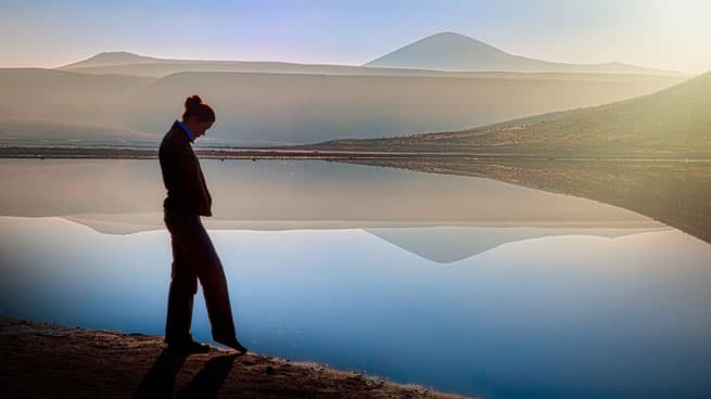 woman by a lake looking down